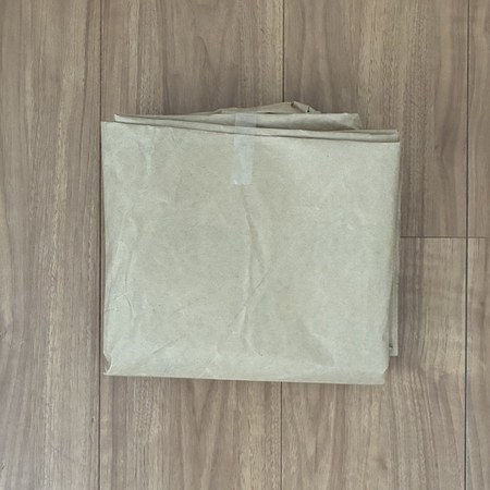 段ボールではなく包装紙で届いたトイレットペーパーの包装紙をたたんだところ